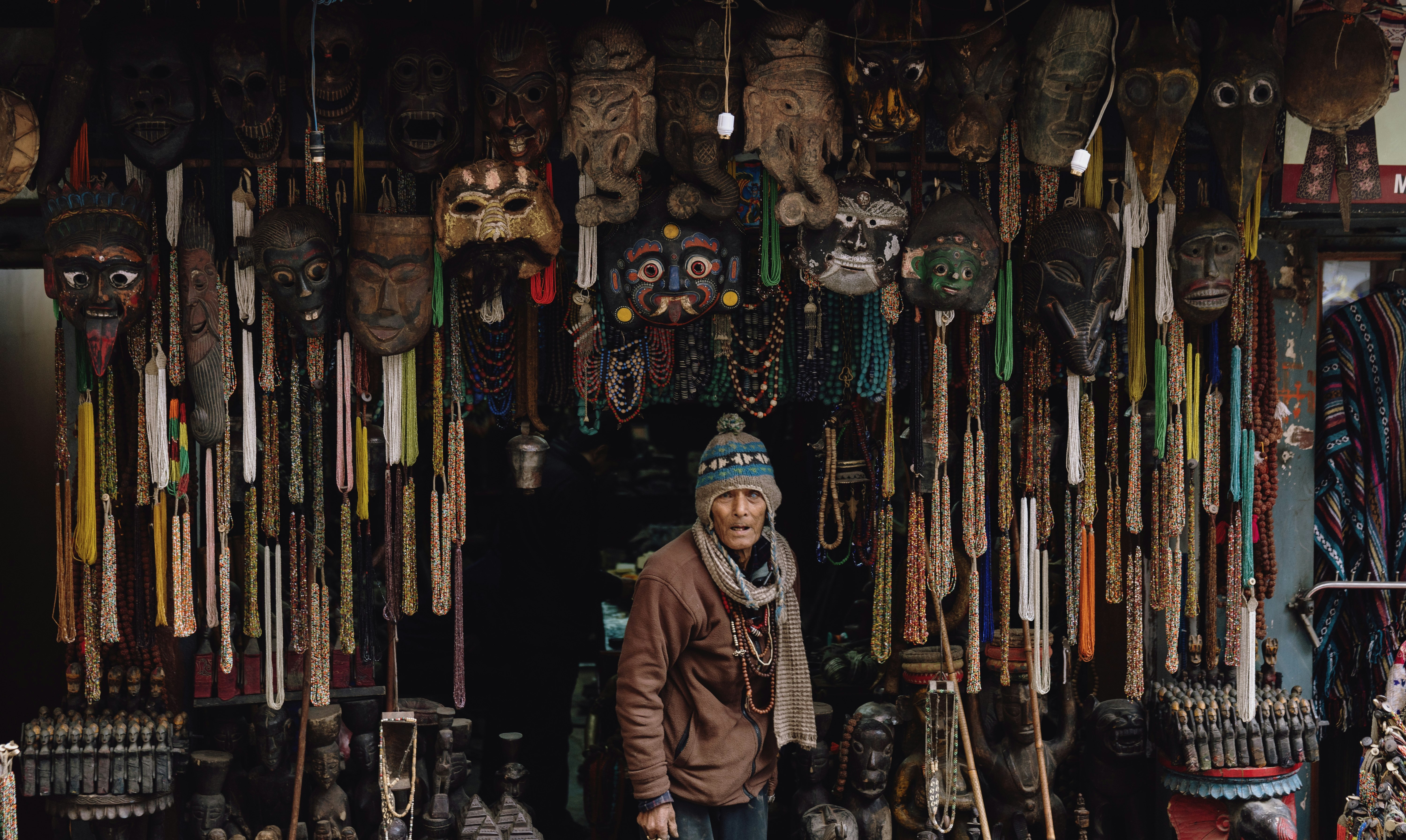 man in brown jacket standing below hanging decors